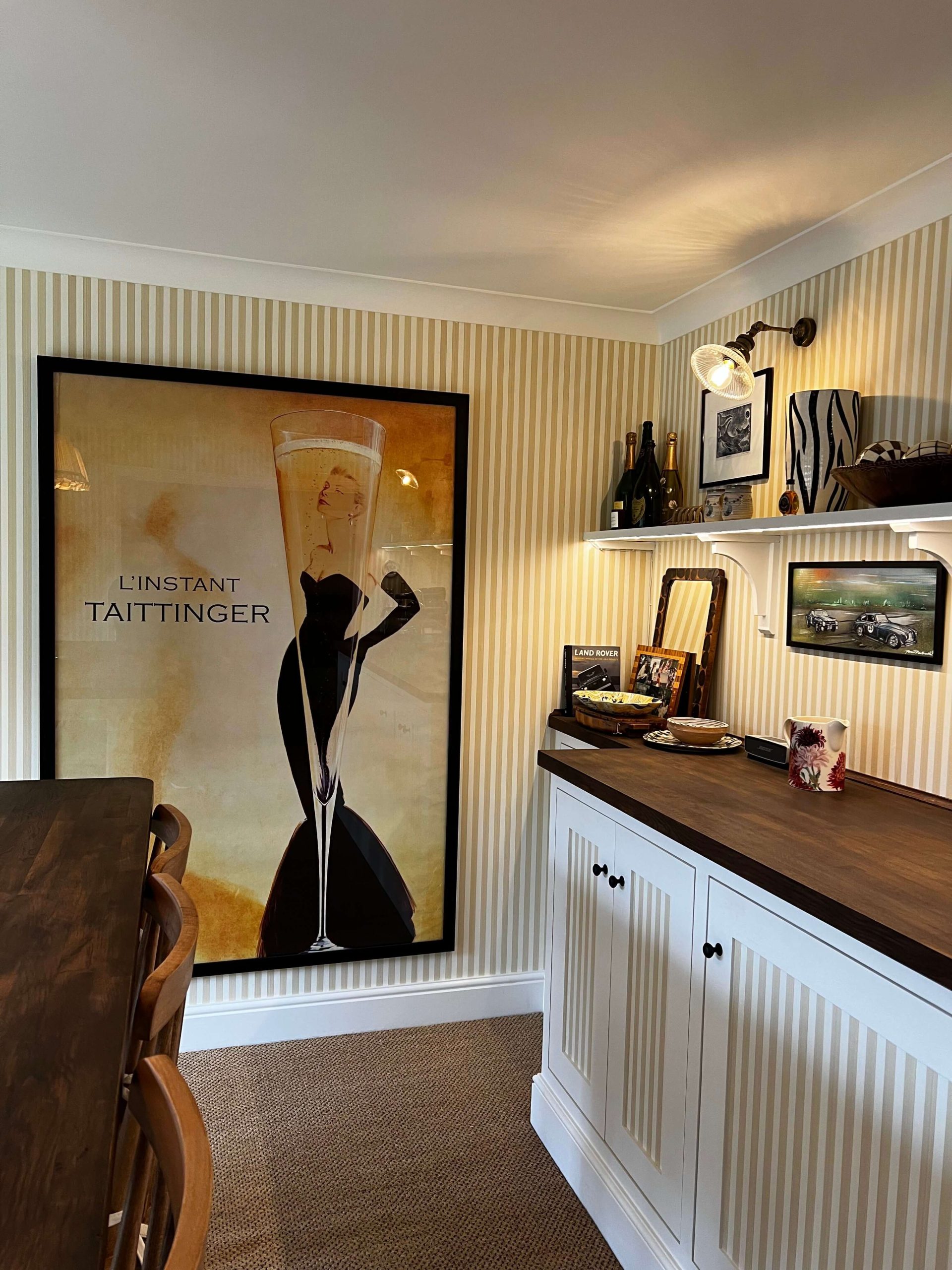 Painted sideboard with fluted doors and dark timber worktop in a striped dining room